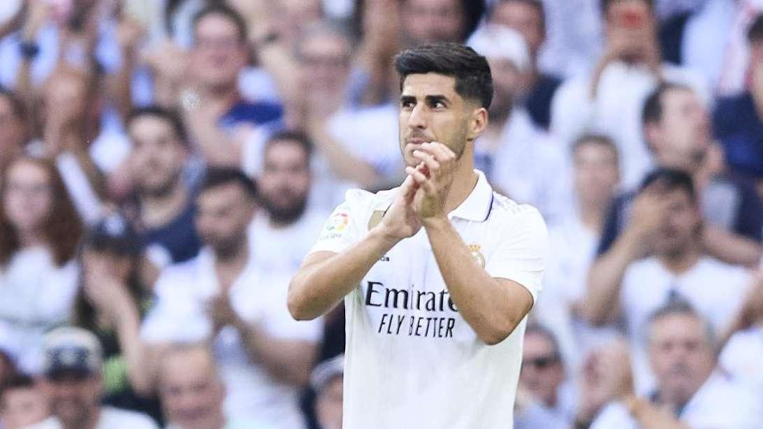 Marco Asensio posa con sus trofeos en el césped del Santiago Bernabéu